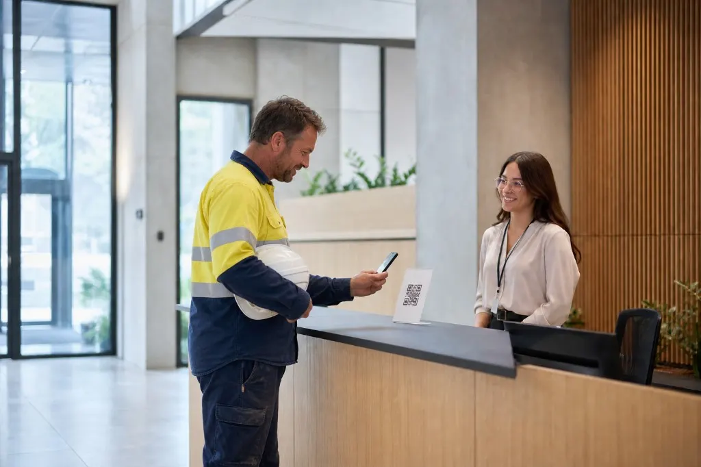 Worker scanning a QR code at a reception desk during site induction.